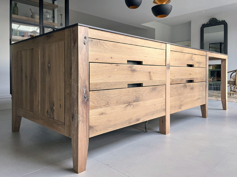 Medium oak island with dark drawer fronts and white worktop under a skylight