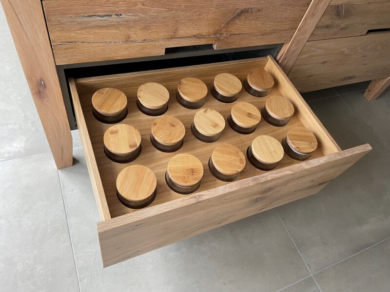 Glass storage jars with wooden lids in a deep drawer